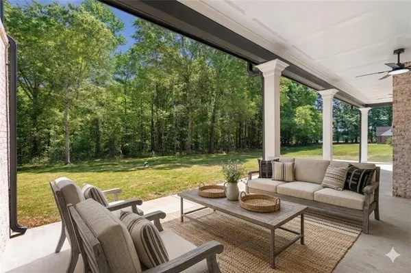 a view of a patio with couches potted plants and a big yard