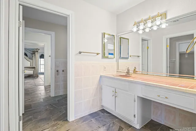 a spacious bathroom with a double vanity sink a mirror and a shower