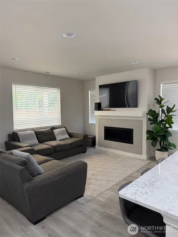 a living room with furniture a flat screen tv and a fireplace