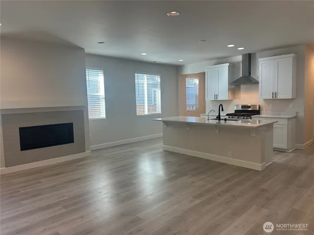 a kitchen with stainless steel appliances granite countertop a stove top oven a sink and a white cabinets