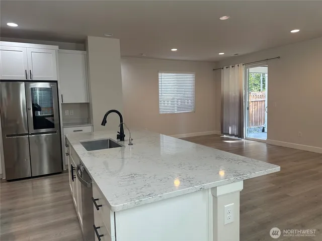 a kitchen with stainless steel appliances granite countertop a sink a stove and a refrigerator