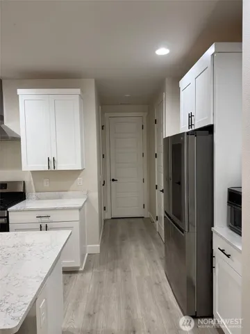 a kitchen with a refrigerator a sink and cabinets