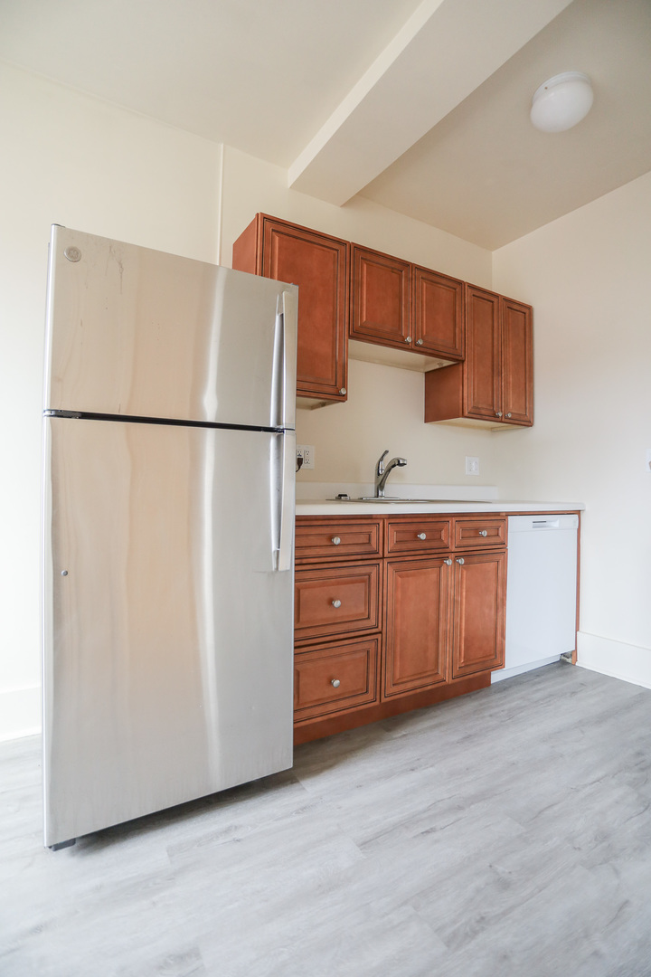 1100 West Roscoe Street, Unit 32 Chicago, IL 60657 - Photo 2 of 8 a kitchen with a refrigerator and a more cabinets