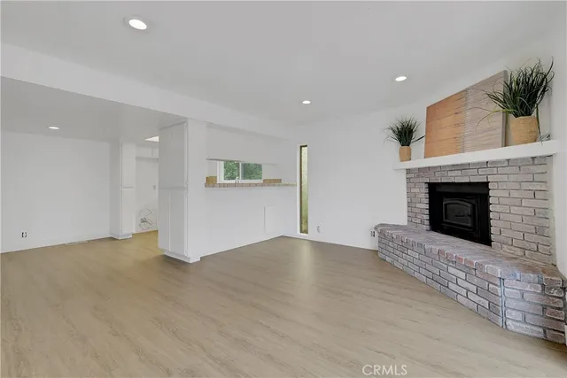 a view of empty room with wooden floor and fireplace