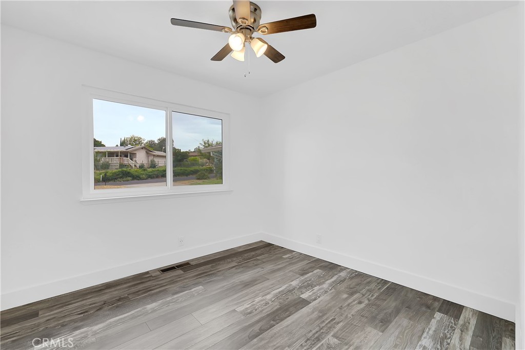 75 Lariat Loop Oroville, CA 95966 - Photo 19 of 47 an empty room with wooden floor ceiling fan and windows