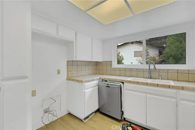 a kitchen with a sink cabinets and wooden floor