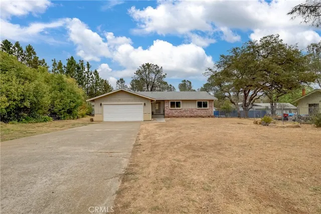 front view of a house with a yard and trees