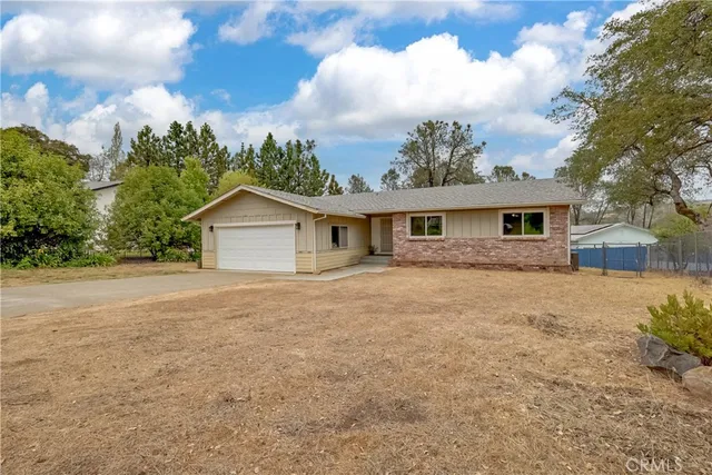 a front view of house with yard and trees in the background