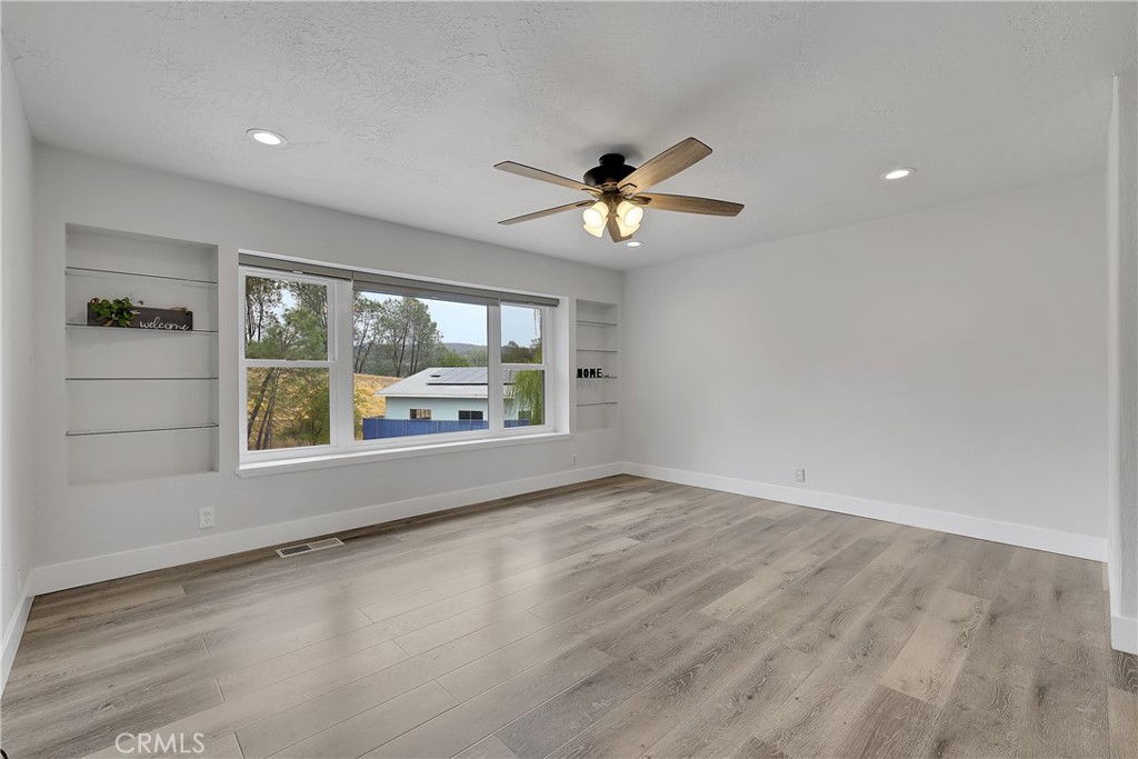 75 Lariat Loop Oroville, CA 95966 - Photo 5 of 47 an empty room with large windows and a ceiling fan