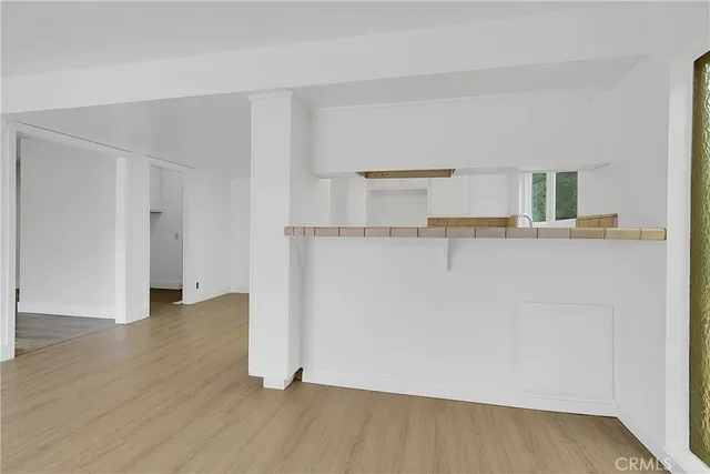 a view of a kitchen with wooden floor and electronic appliances