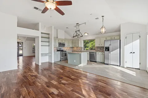 a large kitchen with cabinets and stainless steel appliances