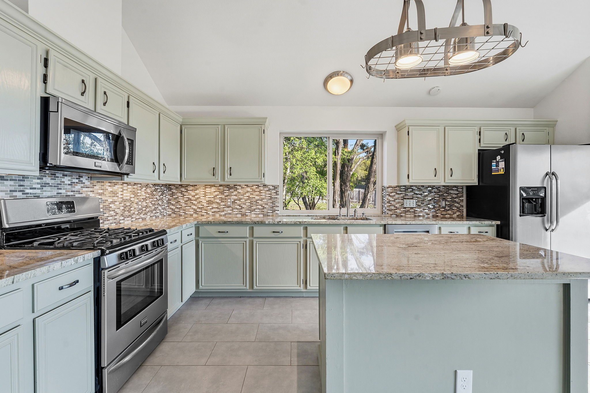 7801 Image Cove Austin, TX 78730 - Photo 9 of 26 a kitchen with stainless steel appliances granite countertop a stove sink and cabinets