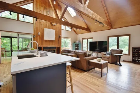 a living room with furniture a flat screen tv and a large window