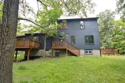 a front view of a house with a garden and plants