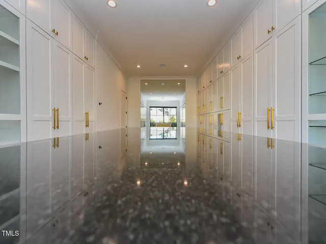 a view of an empty room with a window and kitchen view