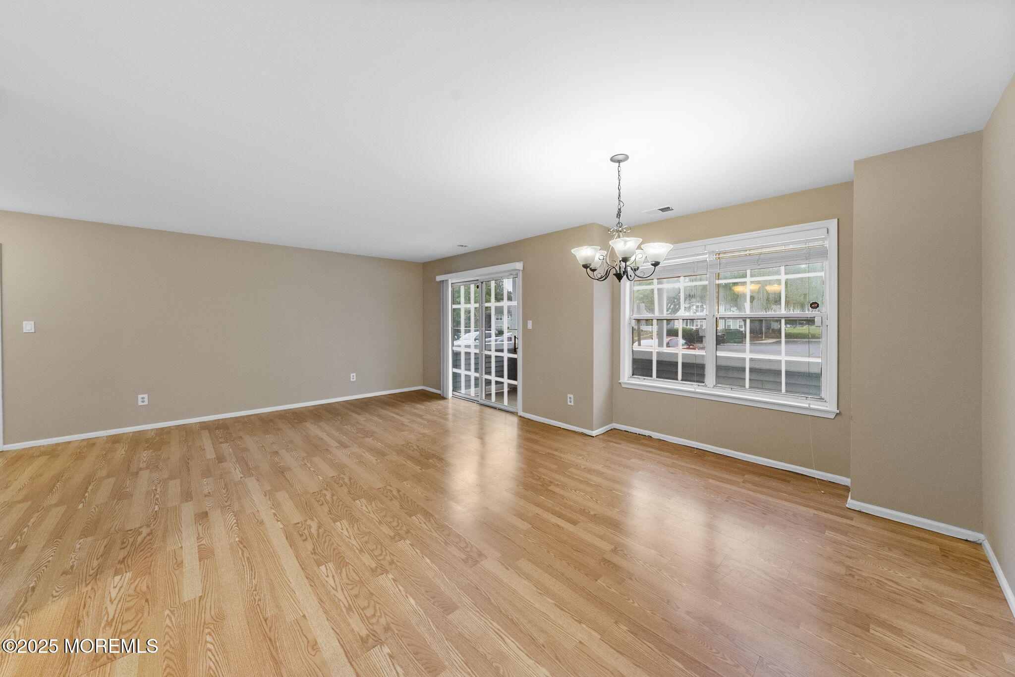 353 Sequoia Court Howell, NJ 07731 - Photo 5 of 27 a view of an empty room with a window and wooden floor
