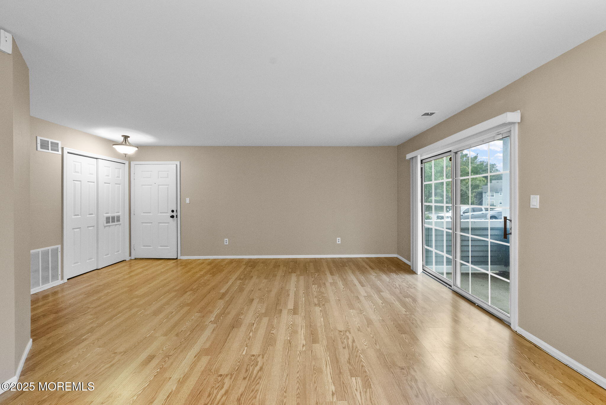 353 Sequoia Court Howell, NJ 07731 - Photo 10 of 27 a view of an empty room with wooden floor and a window