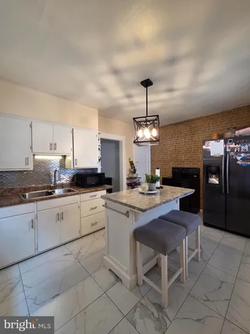 a large kitchen with cabinets chairs and stainless steel appliances