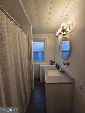 a bathroom with a sink vanity and mirror