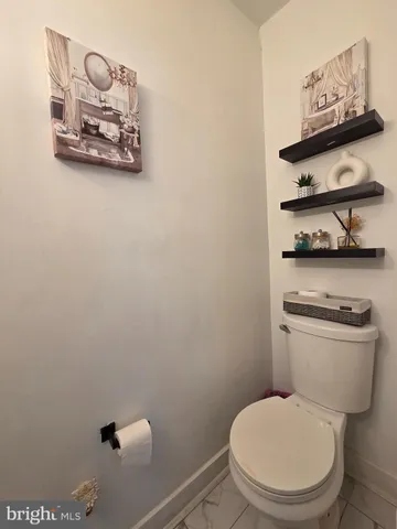 a white toilet sitting next to a small bathroom