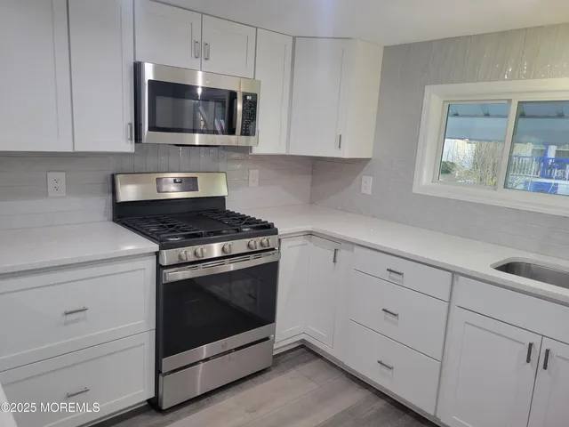 a kitchen with white cabinets and stainless steel appliances