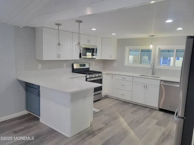 a kitchen with white cabinets stainless steel appliances and sink