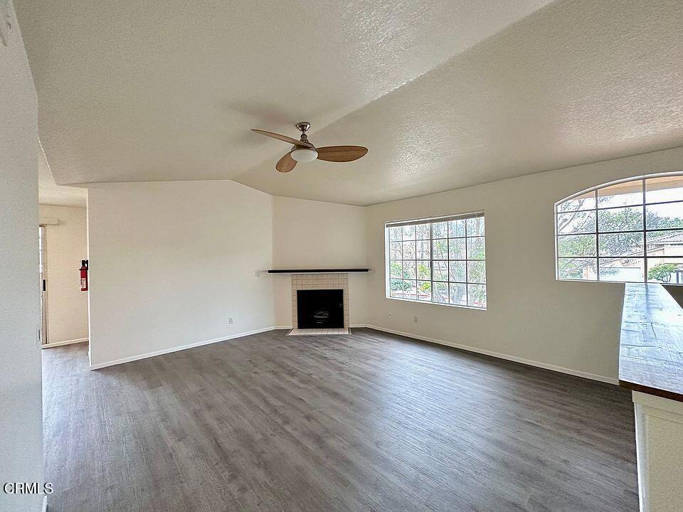 2077 Blackberry Circle Oxnard, CA 93036 - Photo 3 of 20 an empty room with wooden floor fireplace and windows