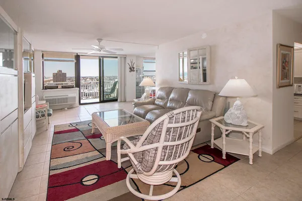 a living room with furniture a flat screen tv and a window