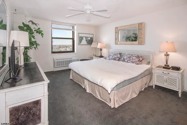 a spacious bedroom with a bed couch and a window