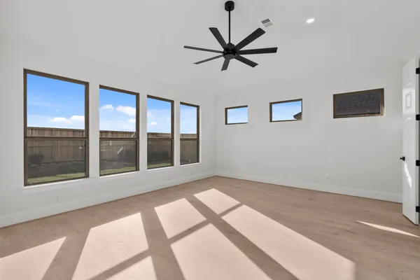 a view of an empty room with a window and a ceiling fan