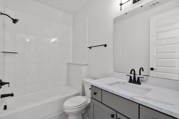 a bathroom with a granite countertop sink a toilet and shower