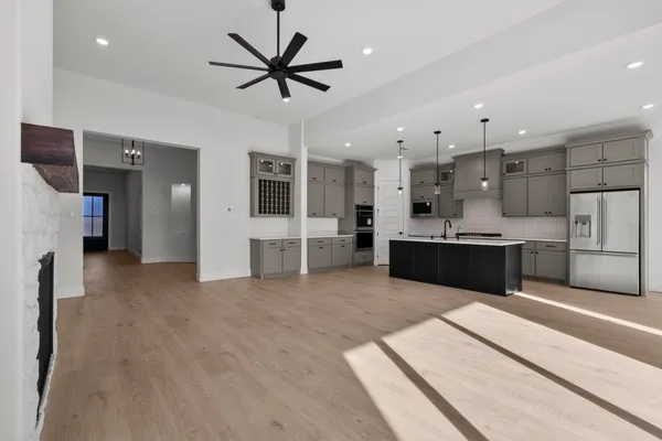 a large white kitchen with a refrigerator a oven and a sink