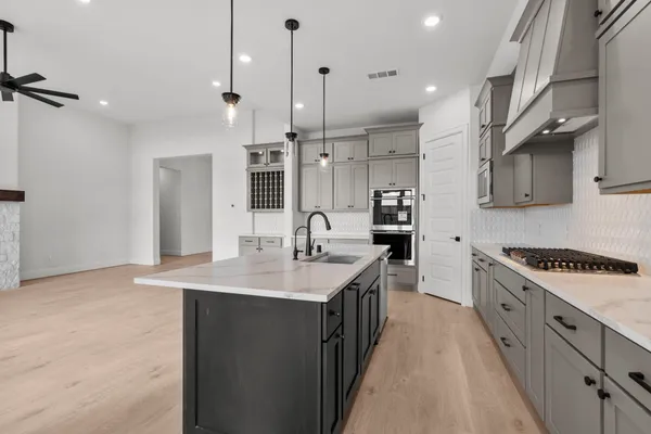 a kitchen with stainless steel appliances kitchen island a sink stove and cabinets