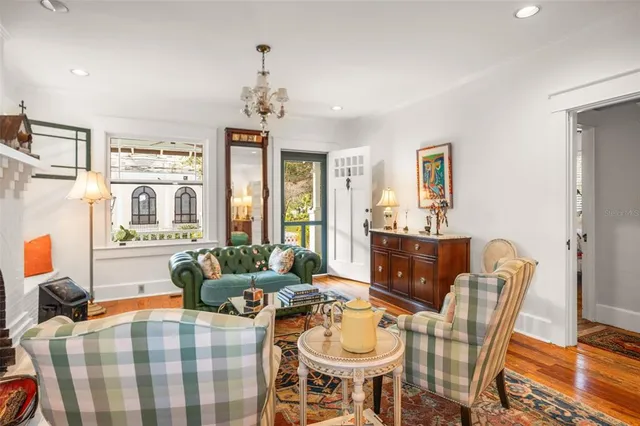 a living room with furniture a fireplace and a dining table with wooden floor