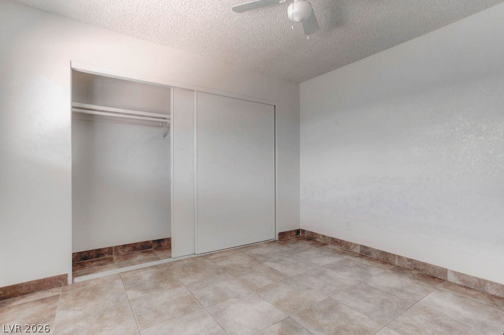 421 North Decatur Boulevard, Unit 2 Las Vegas, NV 89107 - Photo 19 of 21 A well-proportioned room featuring tile flooring and a functional closet with sliding doors, ready for personalization.