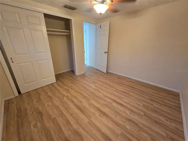 a view of empty room with wooden floor
