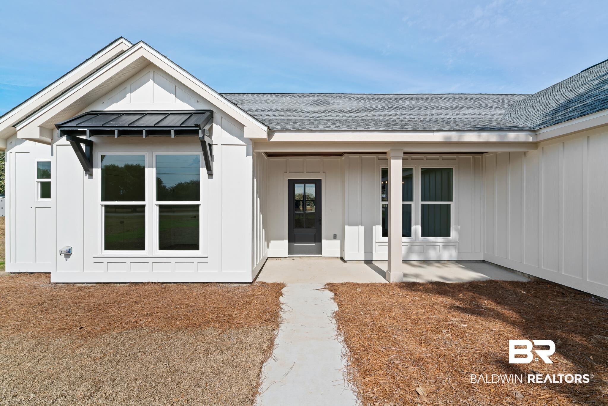 12523 Magnolia Boulevard Foley, AL 36535 - Photo 1 of 1 Doorway to property featuring board and batten siding, roof with shingles, and a porch
