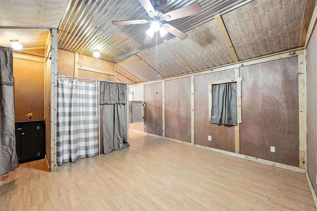 454 Bear Ridge Road Bowie, TX 76230 - Photo 13 of 36 Bonus room with lofted ceiling, wood finished floors, wooden walls, and a ceiling fan