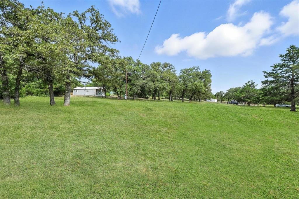 454 Bear Ridge Road Bowie, TX 76230 - Photo 24 of 36 View of grassy yard with view of wooded area