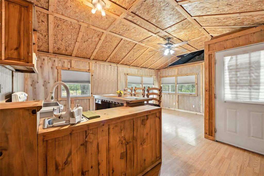 454 Bear Ridge Road Bowie, TX 76230 - Photo 4 of 36 Kitchen with wooden counters, lofted ceiling, light wood-style flooring, ceiling fan, and brown cabinetry