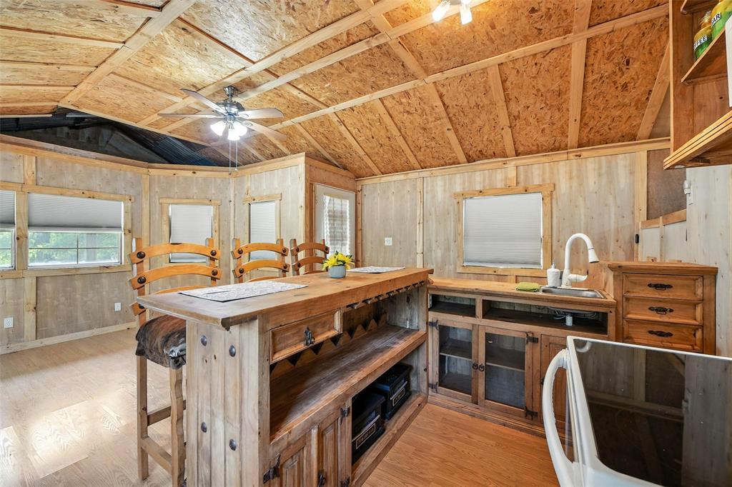 454 Bear Ridge Road Bowie, TX 76230 - Photo 7 of 36 Kitchen featuring lofted ceiling, light wood-type flooring, a ceiling fan, and wood walls