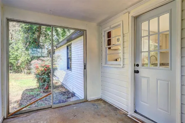 a view of a porch with a floor to ceiling window and wooden floor