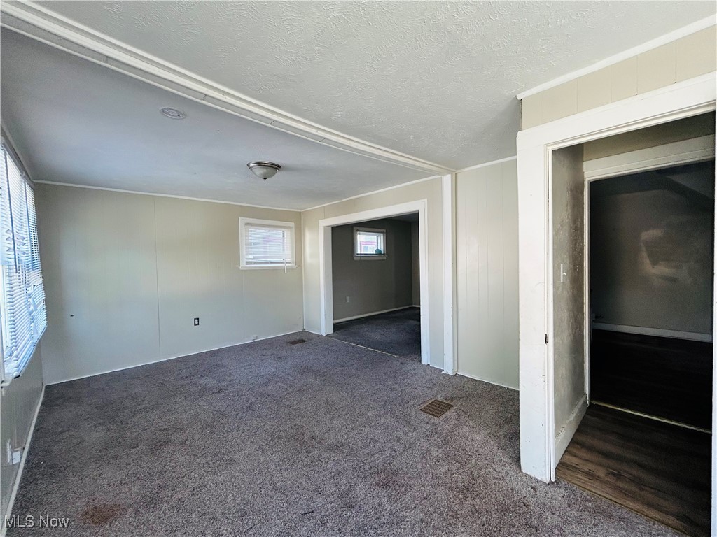 13401 Rugby Road Cleveland, OH 44110 - Photo 10 of 17 Spare room with dark colored carpet and a textured ceiling