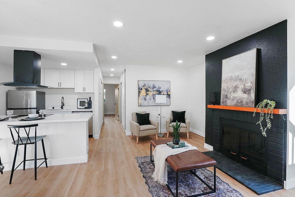 a living room with stainless steel appliances furniture a rug and a flat screen tv
