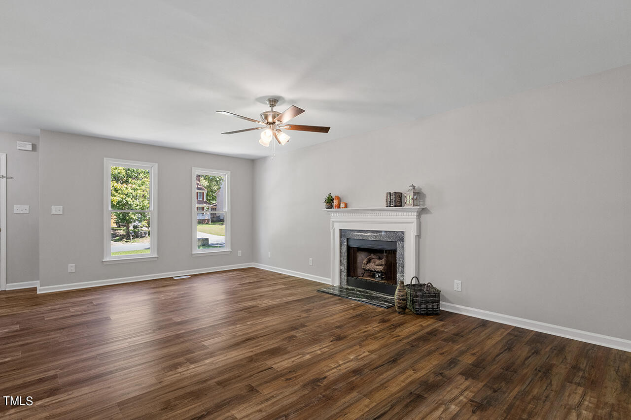 8 Warbler Lane Durham, NC 27712 - Photo 14 of 36 an empty room with windows fireplace and wooden floor