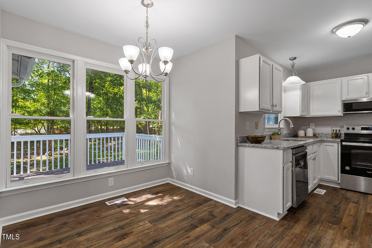 8 Warbler Lane Durham, NC 27712 - Photo 20 of 36 a kitchen with kitchen island granite countertop a stove a sink a center island and wooden floor