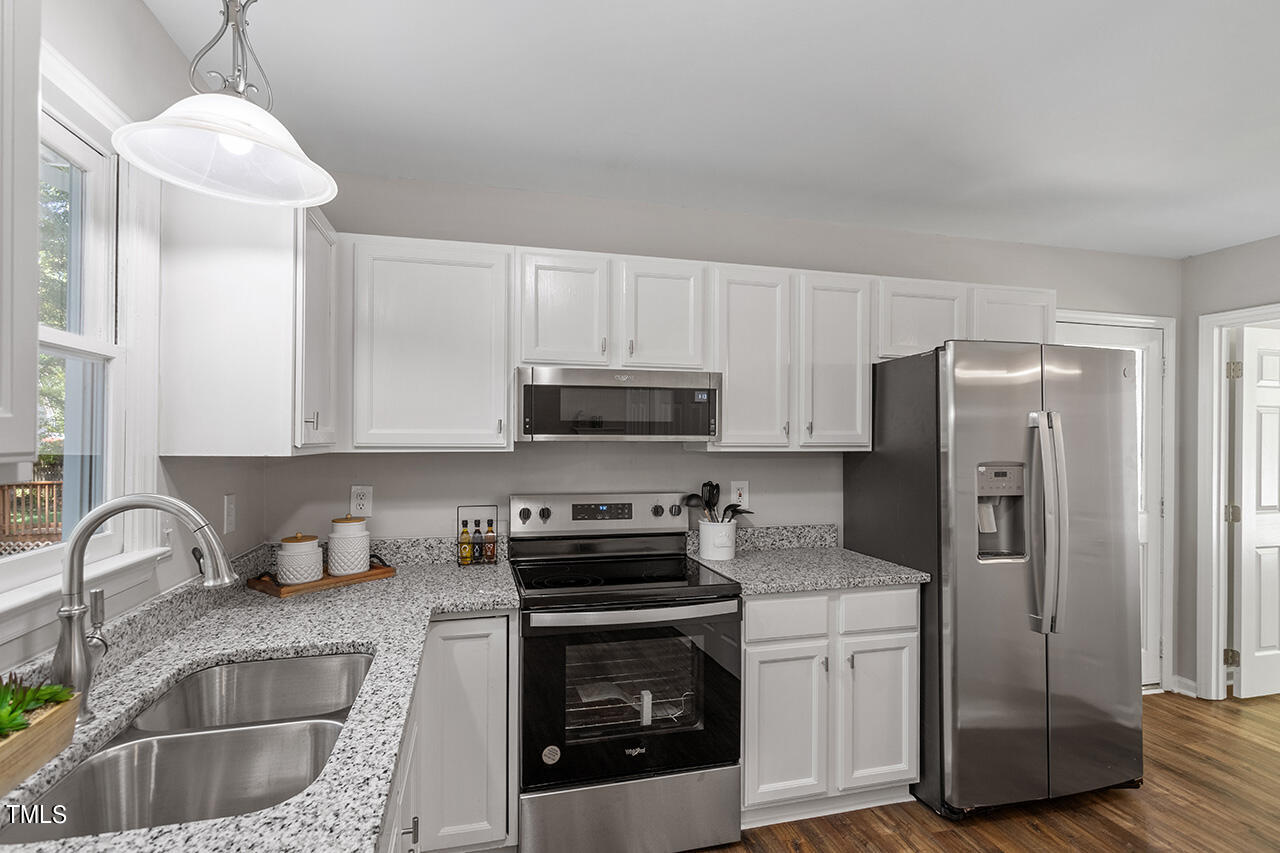 8 Warbler Lane Durham, NC 27712 - Photo 22 of 36 a kitchen with stainless steel appliances granite countertop a refrigerator a stove a sink and white cabinets