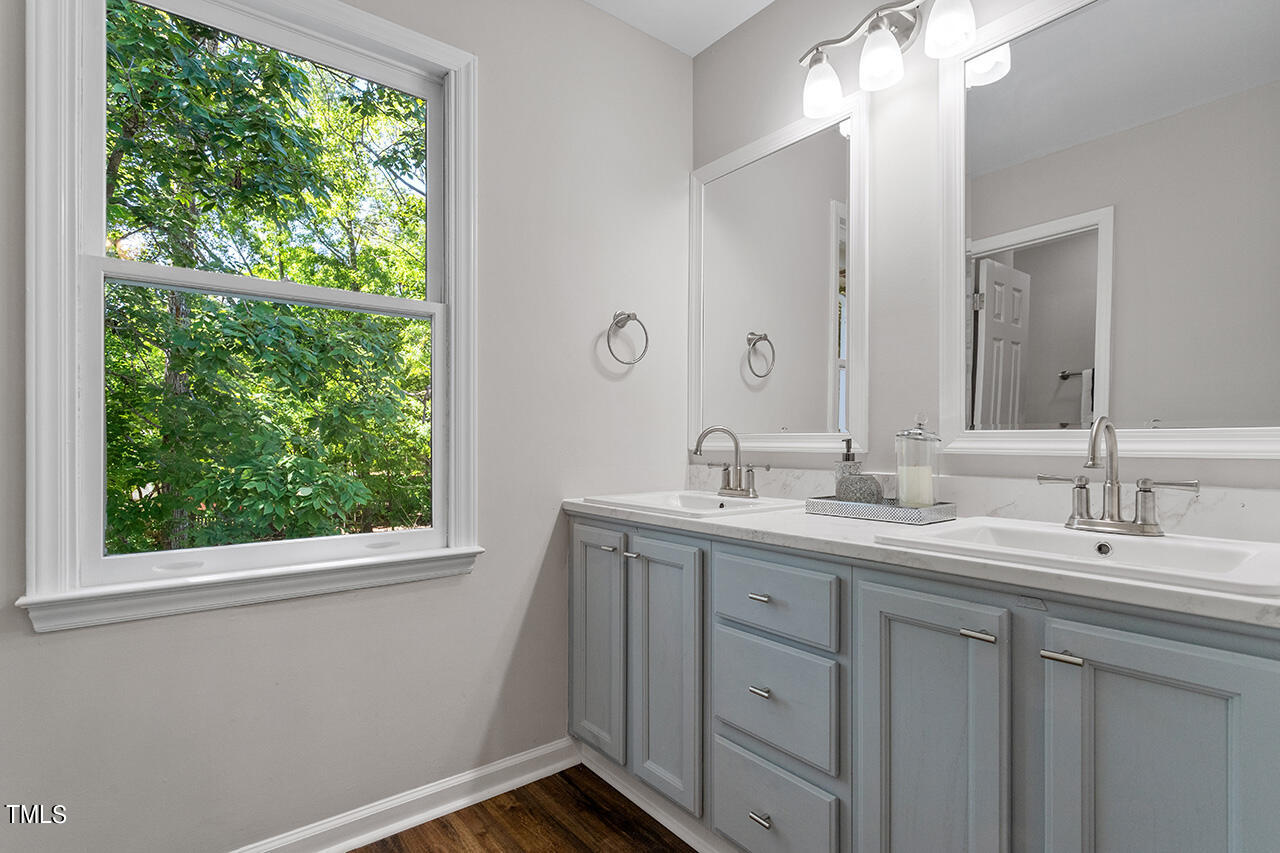 8 Warbler Lane Durham, NC 27712 - Photo 30 of 36 a bathroom with a double vanity sink a mirror and a window