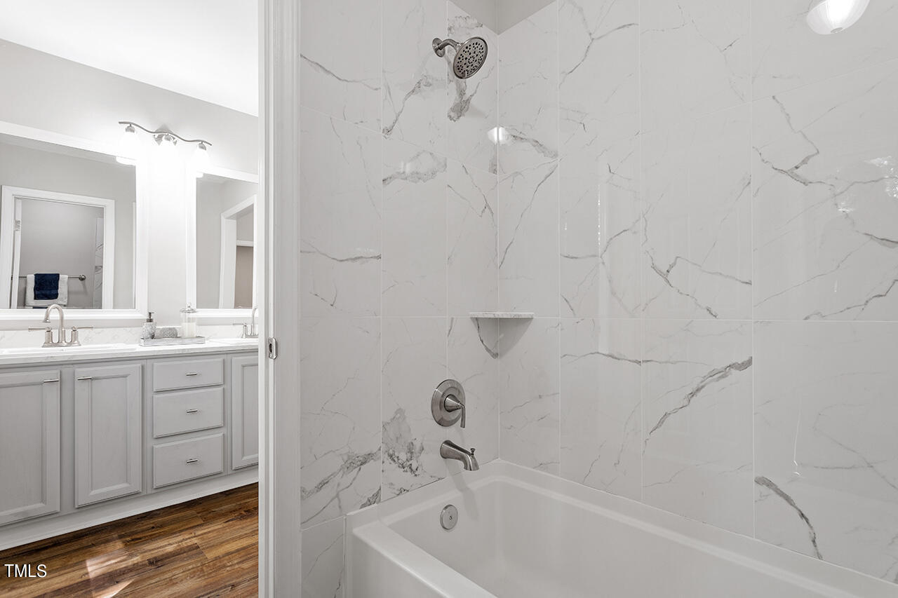 8 Warbler Lane Durham, NC 27712 - Photo 31 of 36 a bathroom with a bathtub sink a mirror and shower