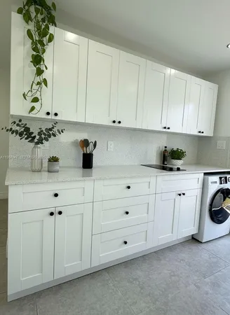 a kitchen with white cabinets and white appliances